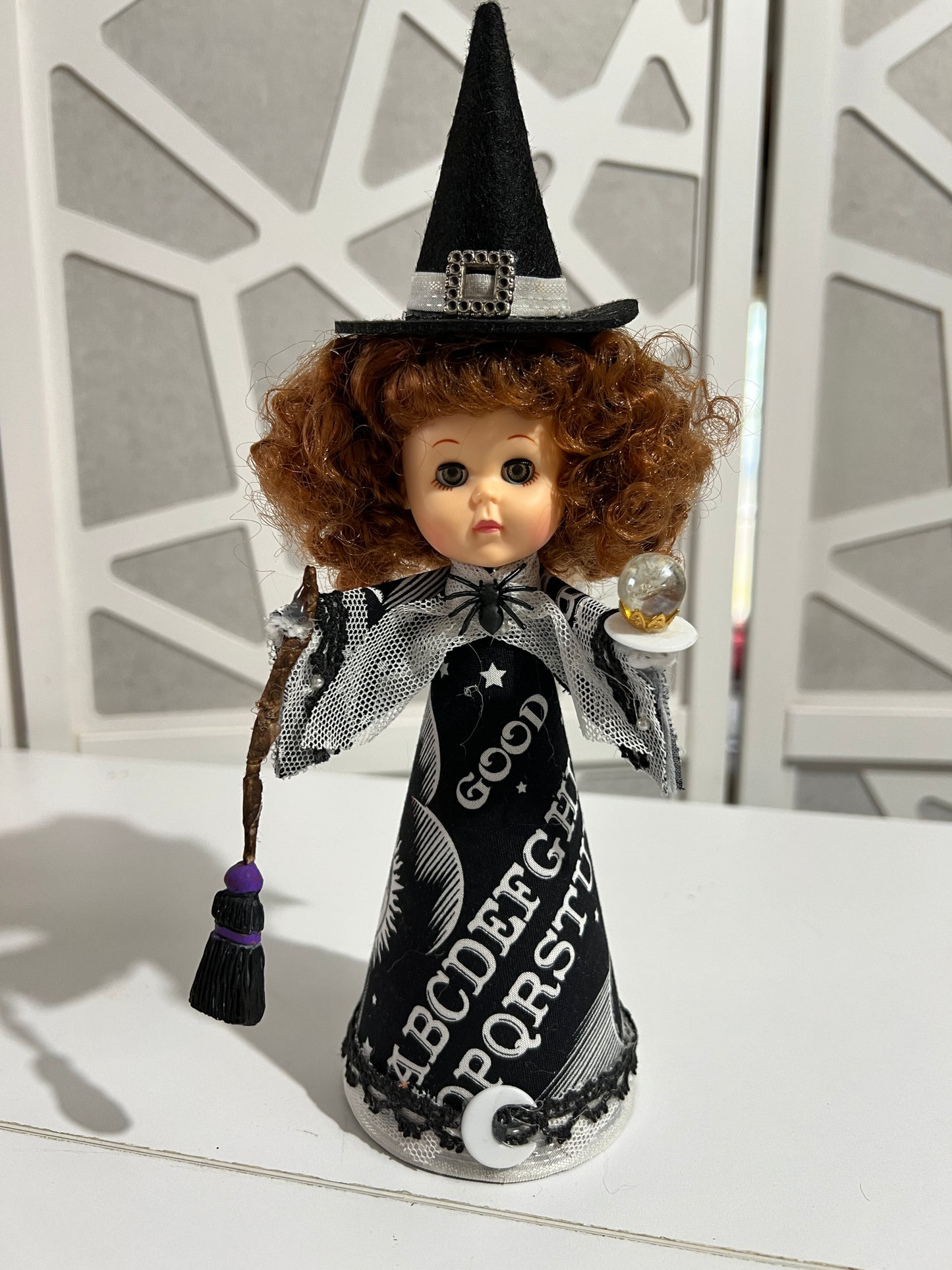 Vintage red haired witch doll with broom and crystal ball.
