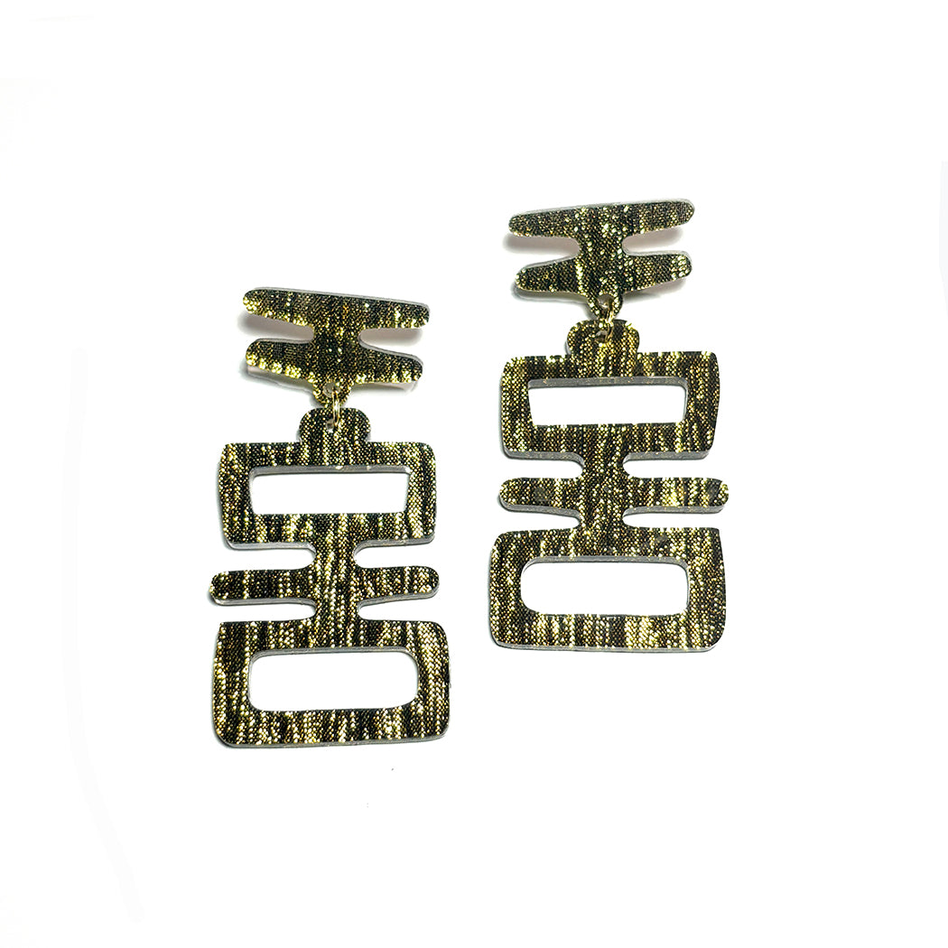 Closeup of Golden Idol statement earrings from Audacious Studio.