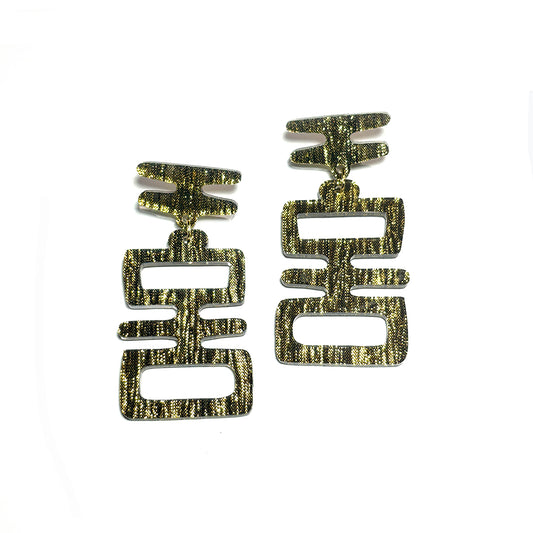 Closeup of Golden Idol statement earrings from Audacious Studio.