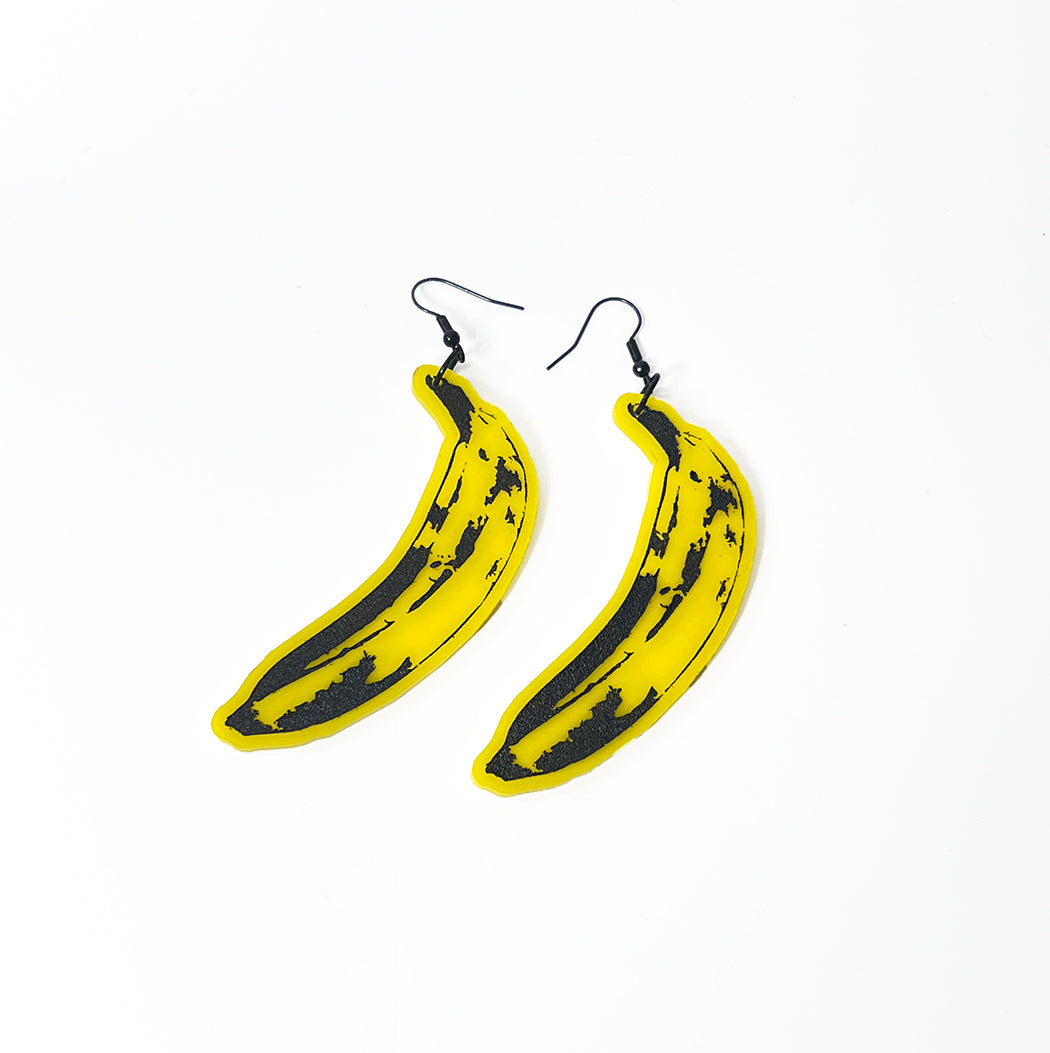 Yellow acrylic pop art banana earrings on white background