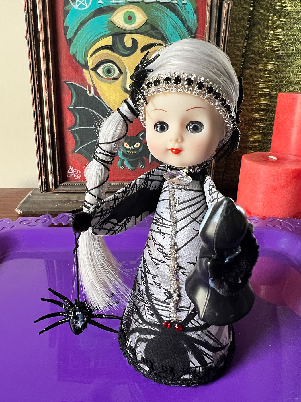Vintage looking Spider web doll with decorative elements on a purple surface
