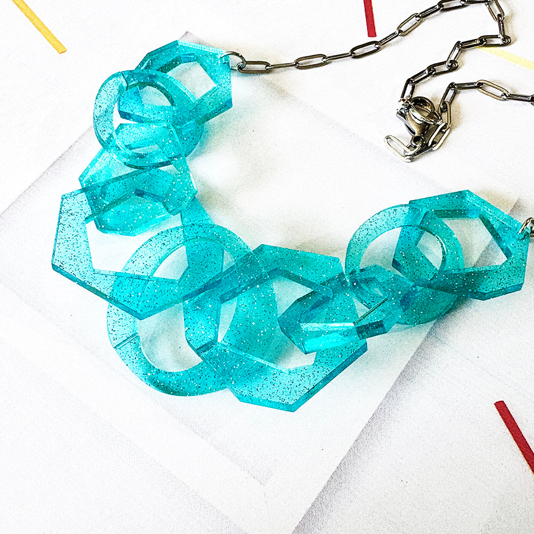 Clear Turquoise glitter chain necklace on a white background