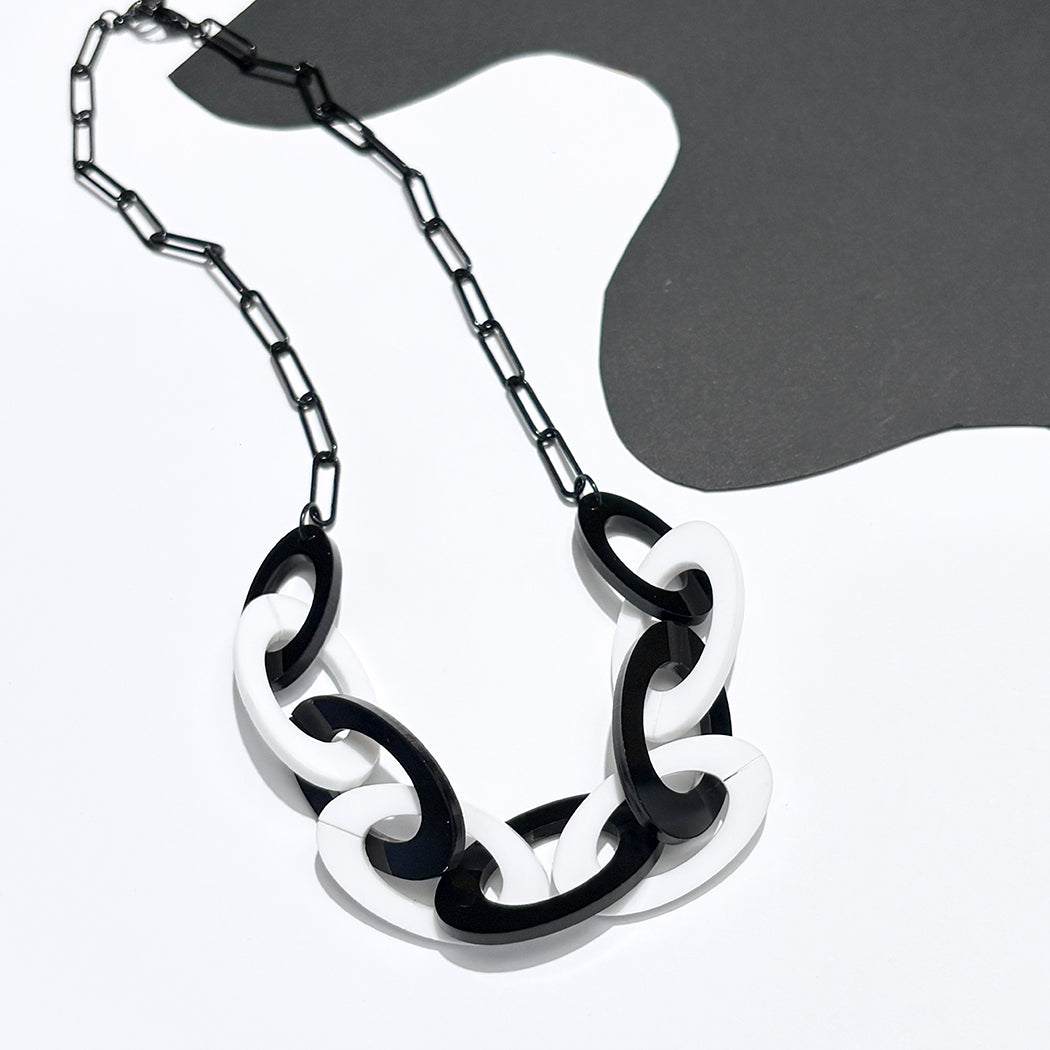 Black and white acrylic chunky chain necklace on a white and black
 background