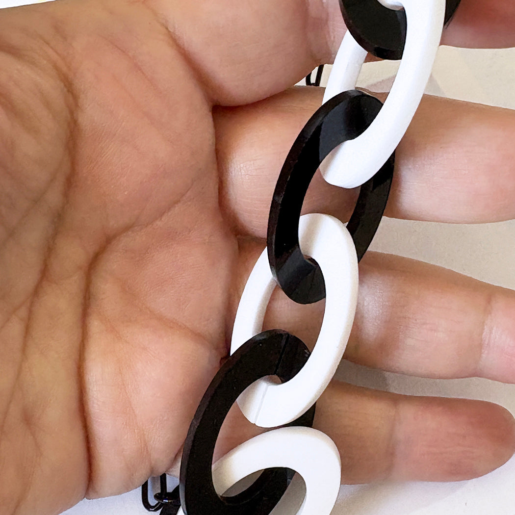 Hand holding a black and white chain