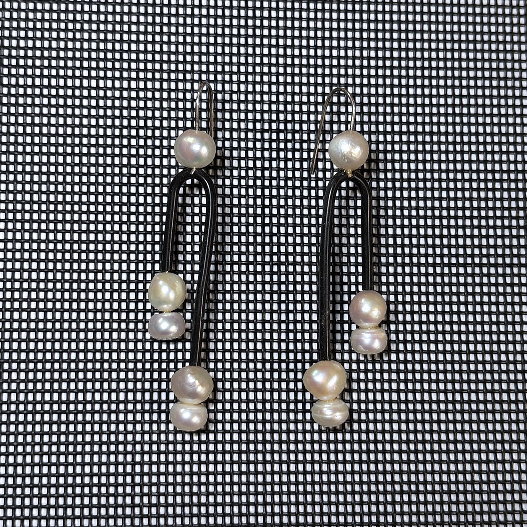 Close up of Post Modern Pearl earrings on black net background from Audacious Studio