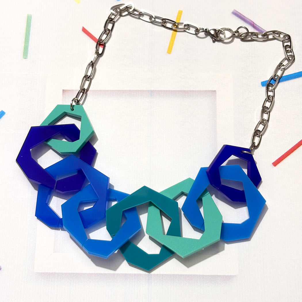 Necklace with blue and aqua geometric links on a white background