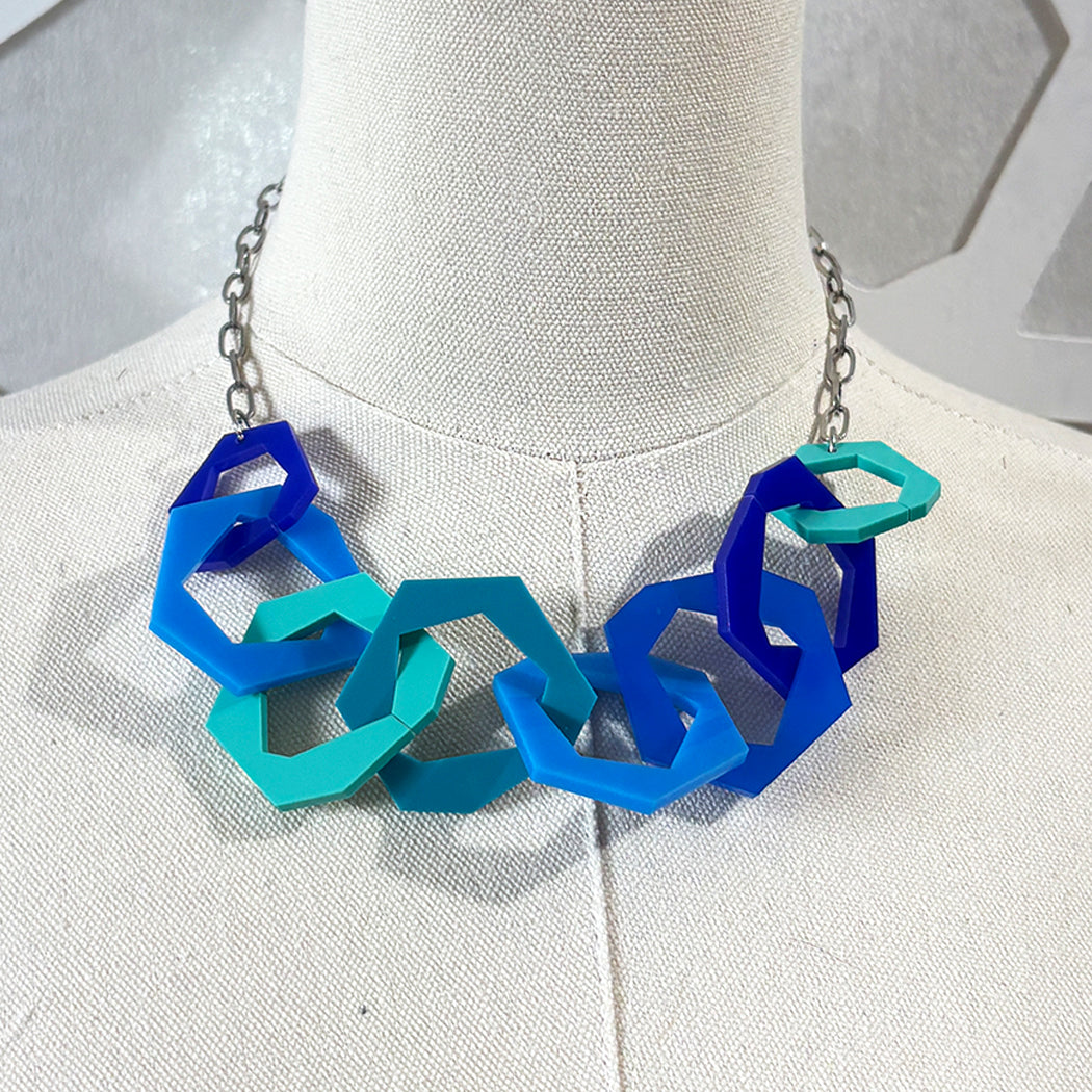 Blue and teal geometric necklace on a mannequin bust.