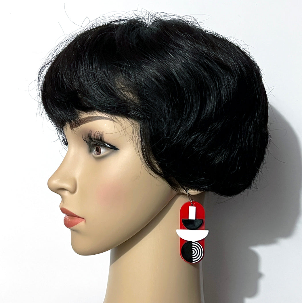 Red, black and white 60s geometric earrings on model.