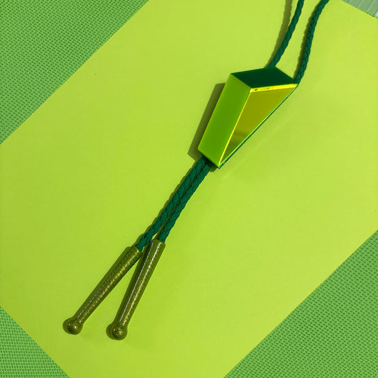 Close up of bright green geometric bolo tie on neon green background from Audacious Studio.
