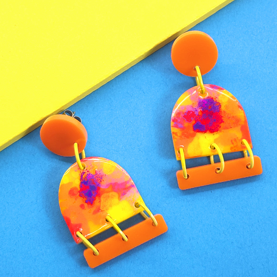 Close up of bold Neon Impressionist earrings in orange, neon yellow, purple and neon pink from Audacious Studio. 