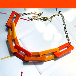 Necklace with orange 
links on a white background