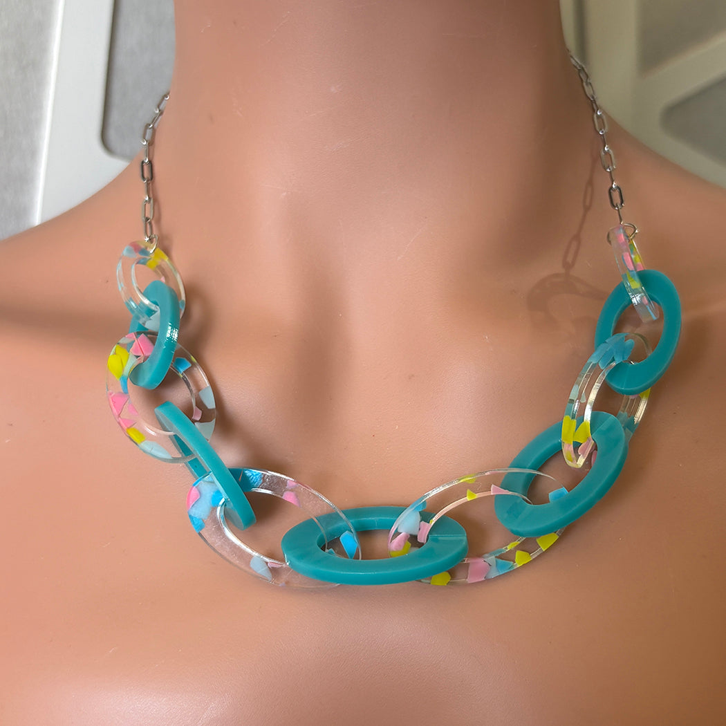 Necklace with peacock blue and clear links on a mannequin