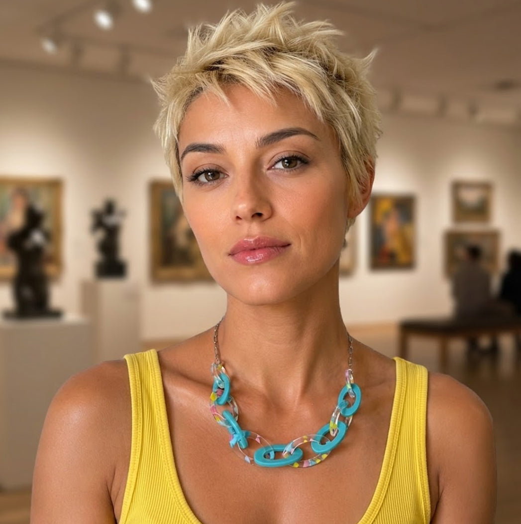 Woman wearing a yellow top and colorful necklace in an art gallery setting