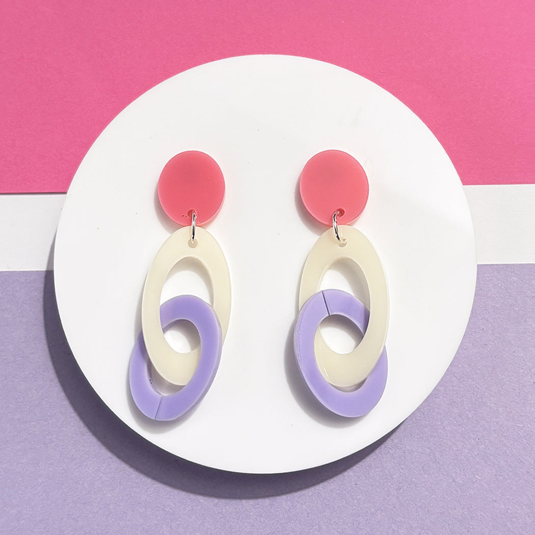 Colorful earrings with pink top and purple and cream oval loops on a pink and purple background