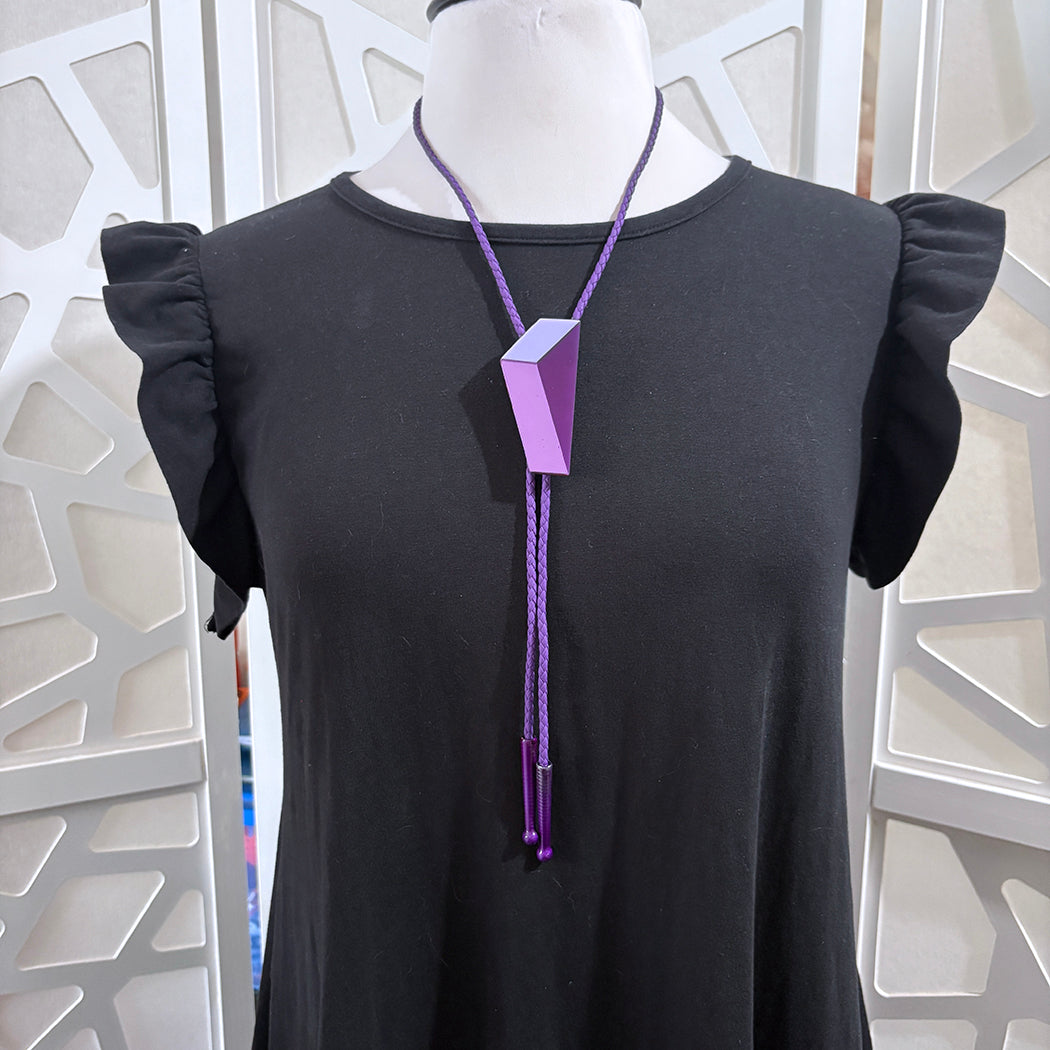 Style shot of modern art inspired bolo tie in purple. 