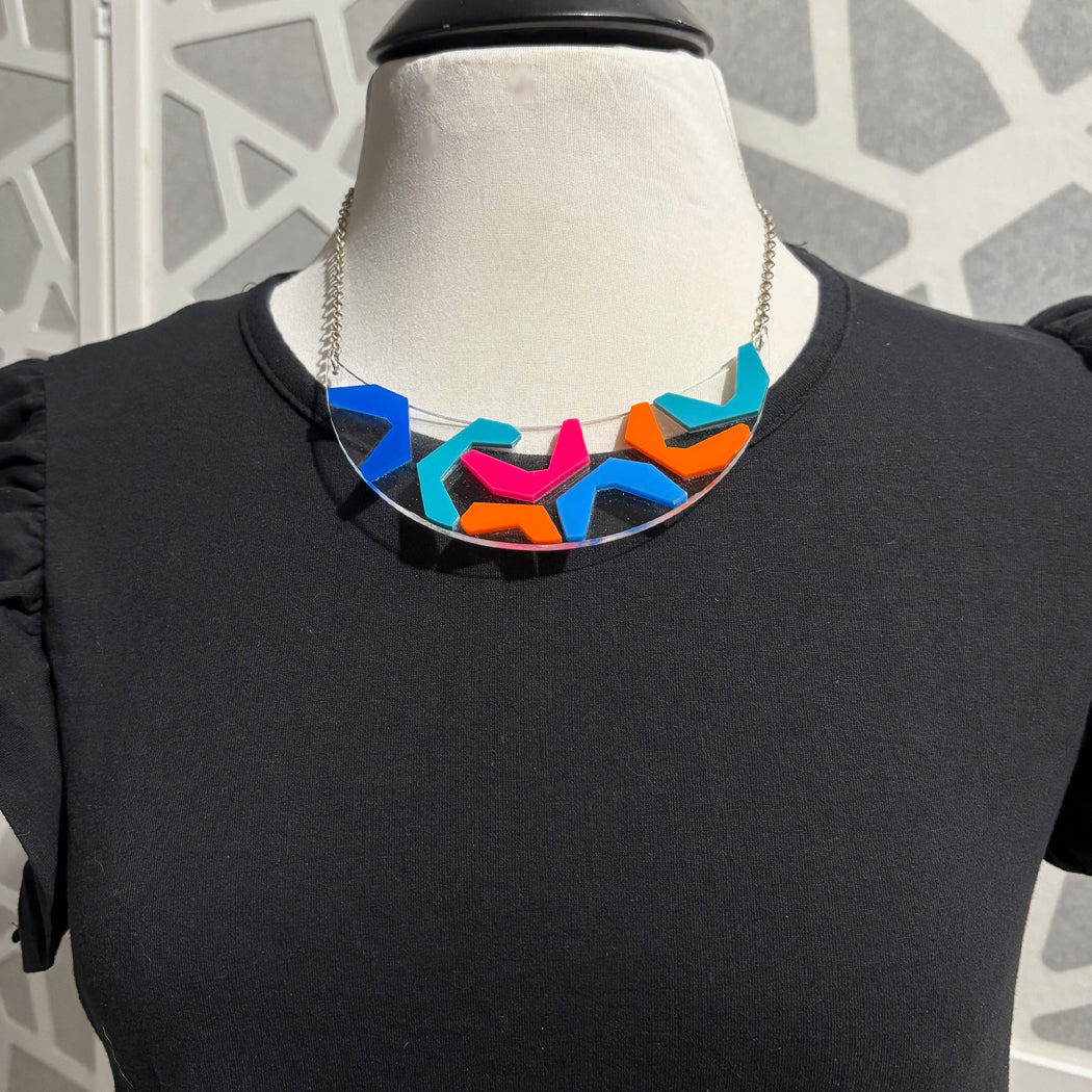 Colorful new wave inspired She Bop bib necklace on a dressform with black top