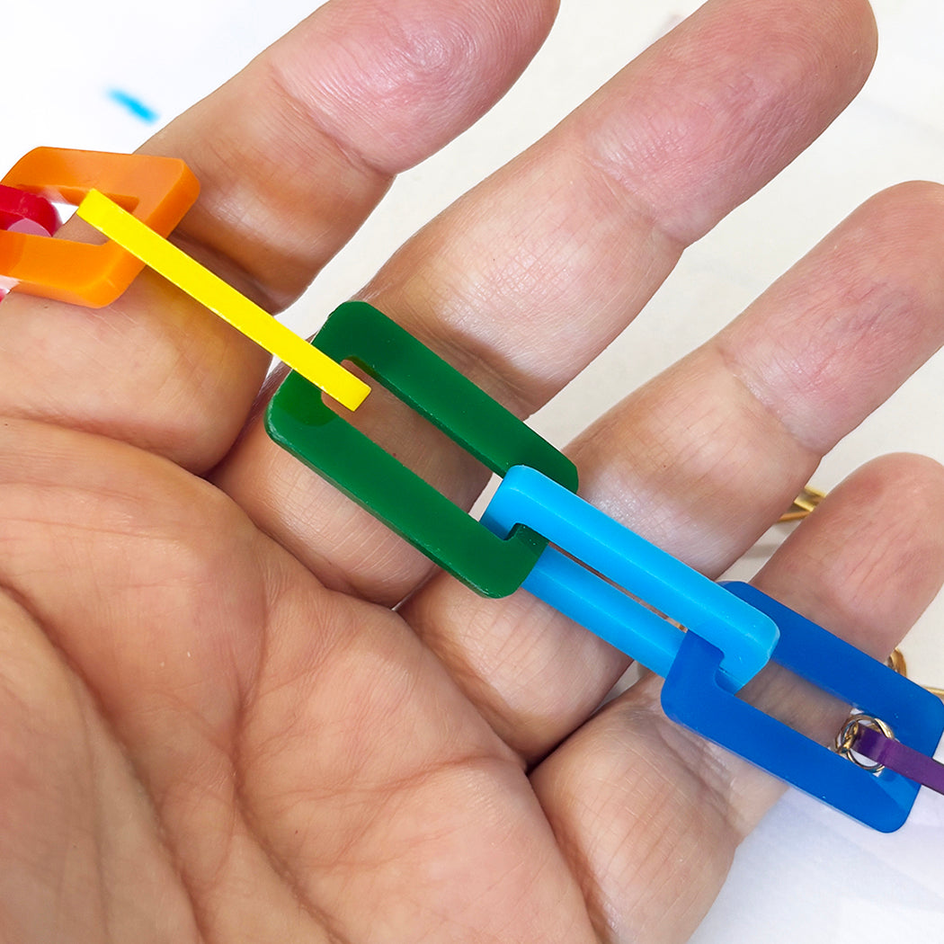 Colorful plastic links on a hand against a white background