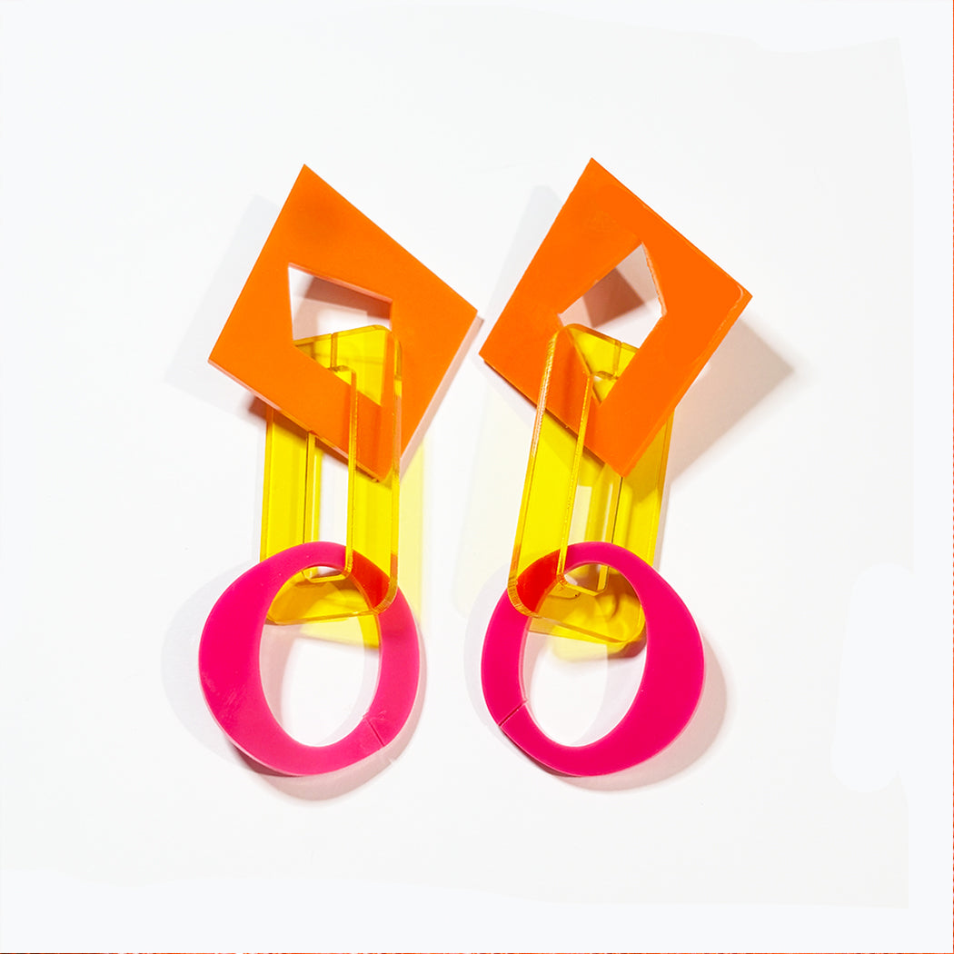 Closeup of large colorful abstract chain link earrings on white background from Audacious Studio. 