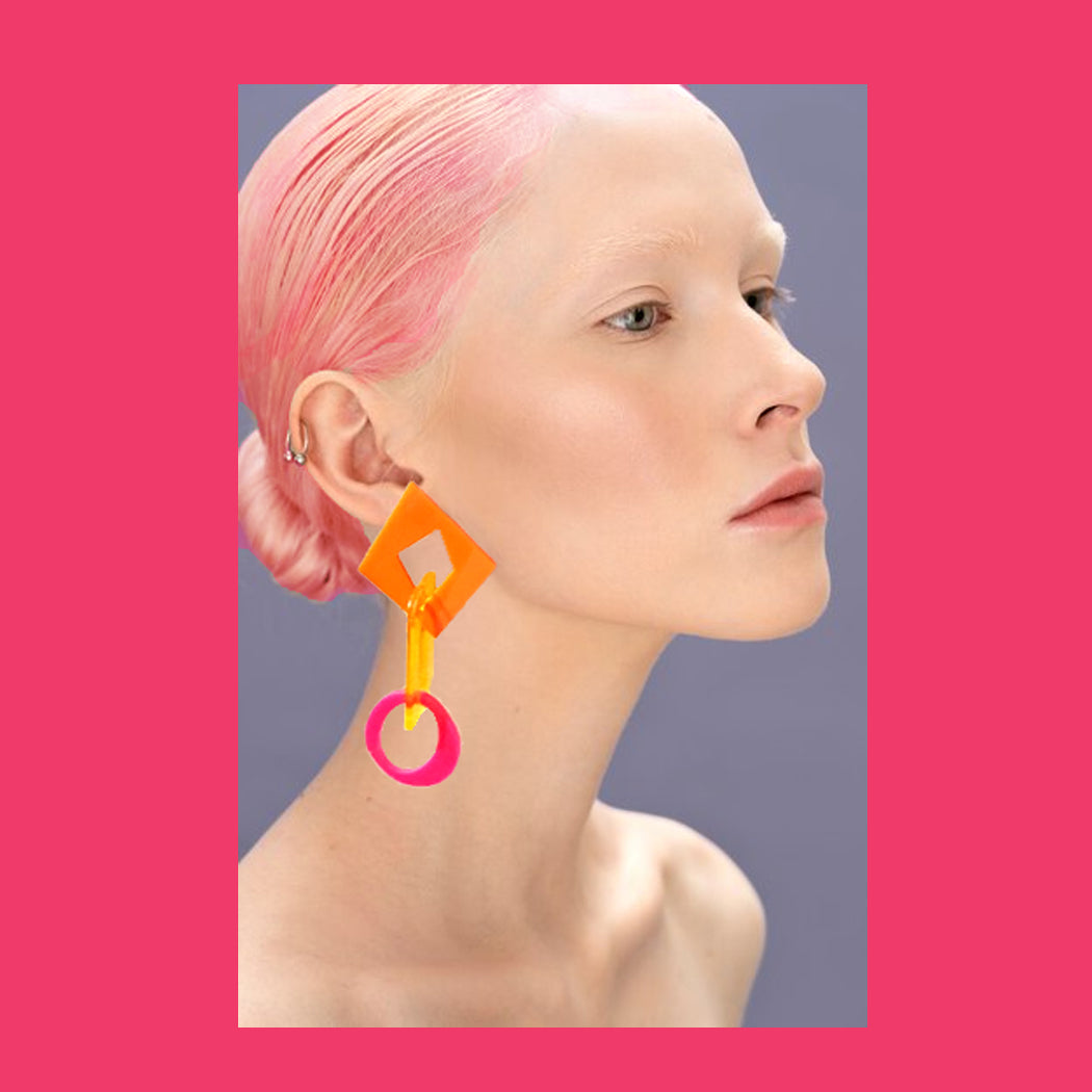 Model wearing mismatched acrylic link statement earrings