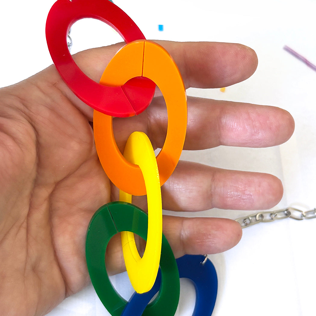 Colorful plastic rings held in a hand against a white background