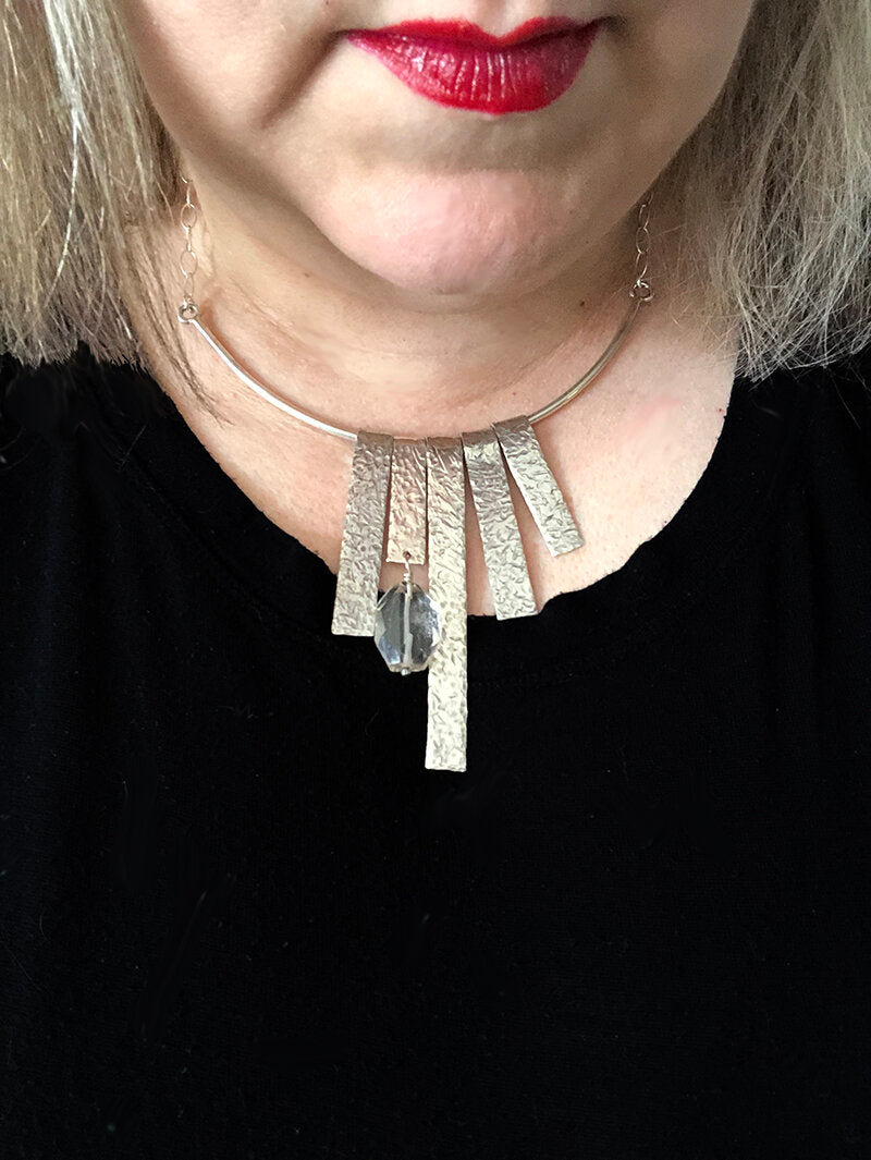 Blonde woman wearing brutalist style fringe sterling fringe necklace with black shirt.